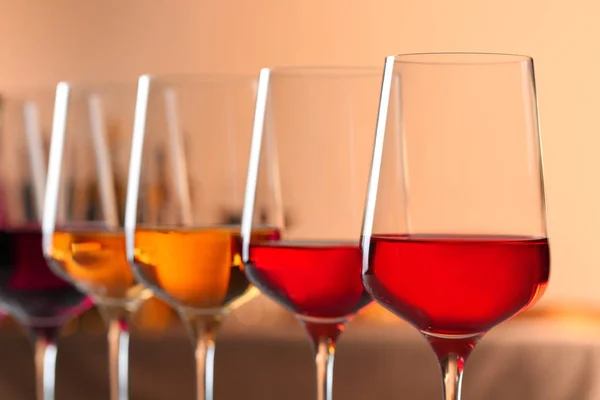 Fila de copos com diferentes vinhos contra fundo desfocado, close-up — Fotografia de Stock