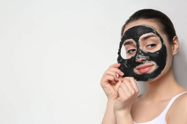 Gyönyörű fiatal nő eltávolítása fekete maszkot az arcát a fehér háttér. Szóköz a szöveghez — Stock Fotó