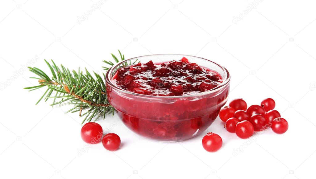 Bowl of cranberry sauce with fir tree branches on white background