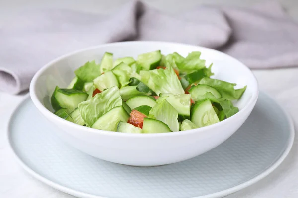 Schüssel vegetarischer Salat mit Gurken, Tomaten und Salat auf dem Tisch — Stockfoto