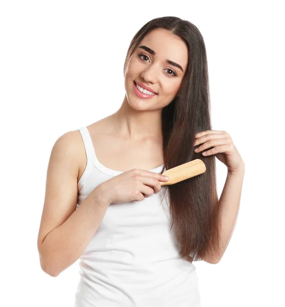 Beautiful smiling young woman with hair brush on white background — Stock Photo, Image