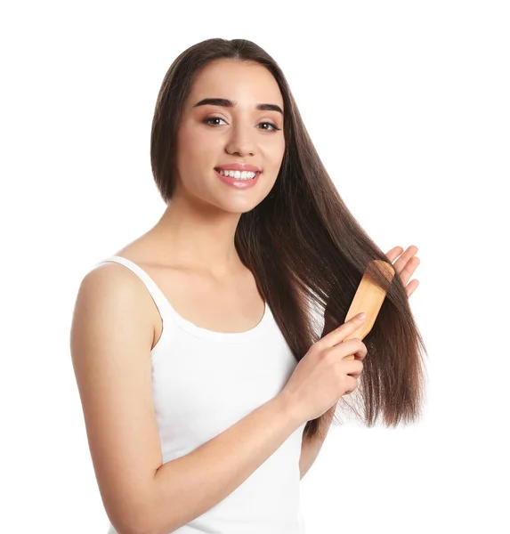 Beautiful smiling young woman with hair brush on white background — Stock Photo, Image