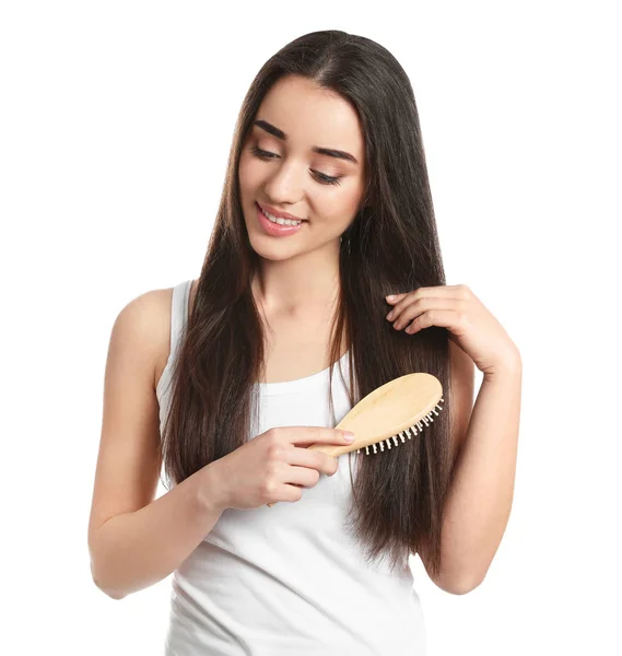 Beautiful young woman with hair brush on white background — Stock Photo, Image