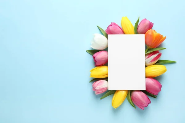 Gyönyörű kompozíció tavaszi virágok és az üres kártyát a színes háttér, felülnézet. Szóköz a szöveghez — Stock Fotó