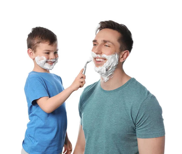 Pequeño hijo afeitando a su padre sobre fondo blanco — Foto de Stock