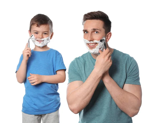 Vader scheren en zoon imiteren hem op witte achtergrond — Stockfoto