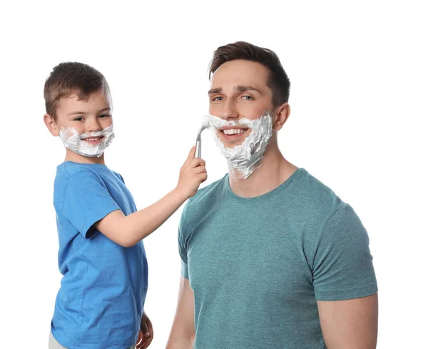 Μικρός γιος που ξυρίζει τον πατέρα του σε λευκό φόντο — Φωτογραφία Αρχείου