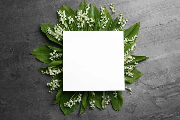 Cartão em branco com lírio das flores do vale sobre fundo cinza, vista superior. Espaço para texto — Fotografia de Stock