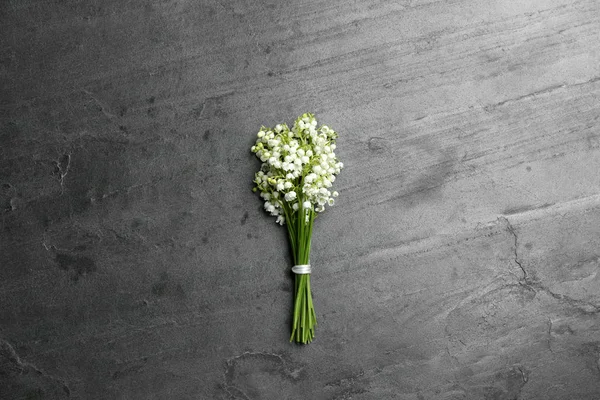 Beautiful lily of the valley bouquet on grey background, top view — Zdjęcie stockowe