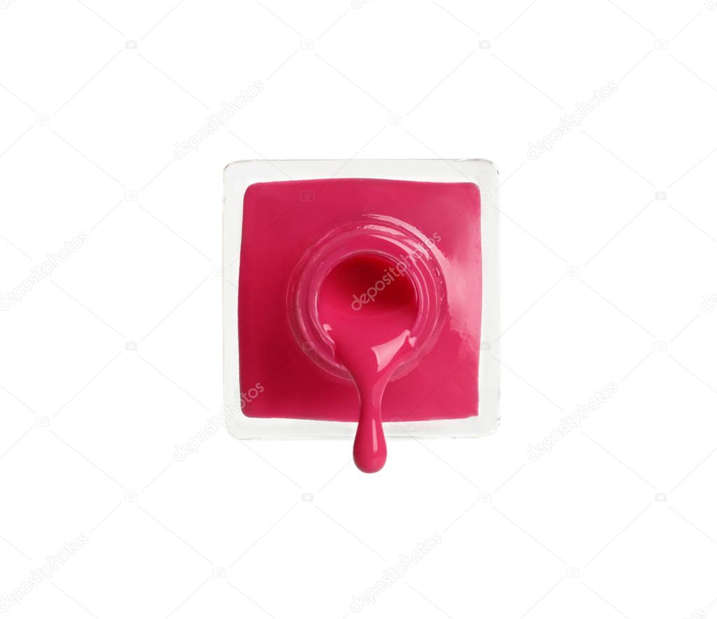 Pouring color nail polish from bottle on white background