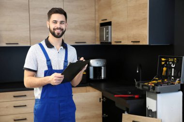 Mutfakta panosu olan erkek tesisatçı. Onarım hizmeti