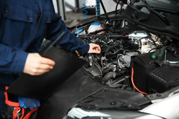Técnico verificando carro moderno na oficina de reparação de automóveis, close-up — Fotografia de Stock