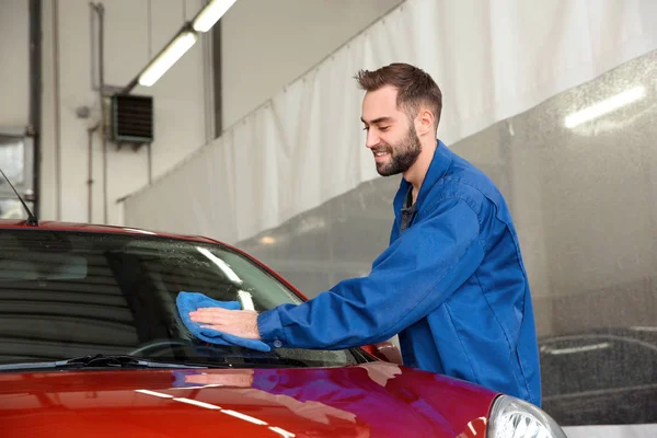 Worker cleaning automobile windshield with rag at car wash — 스톡 사진