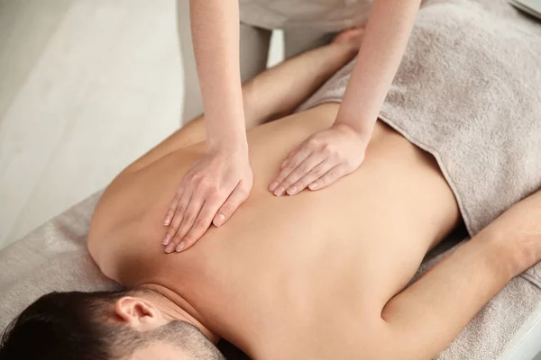 Hombre guapo recibiendo masaje de espalda en el salón de spa, primer plano — Foto de Stock