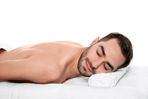 Homem bonito relaxando na mesa de massagem contra fundo branco. Serviço de Spa — Fotografia de Stock