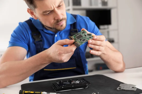 Técnico masculino reparando el disco duro en la mesa en el interior —  Fotos de Stock