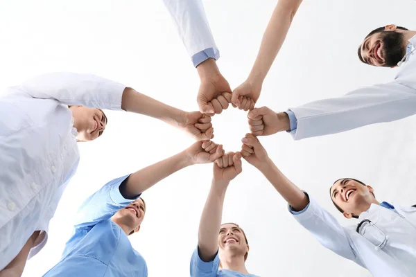Equipa de médicos a juntar as mãos no fundo branco, de perto. Conceito de unidade — Fotografia de Stock