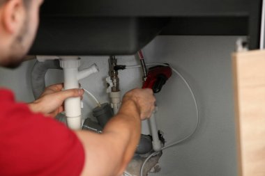 Erkek tesisatçı boru anahtarı ile mutfak lavabo tamir, closeup