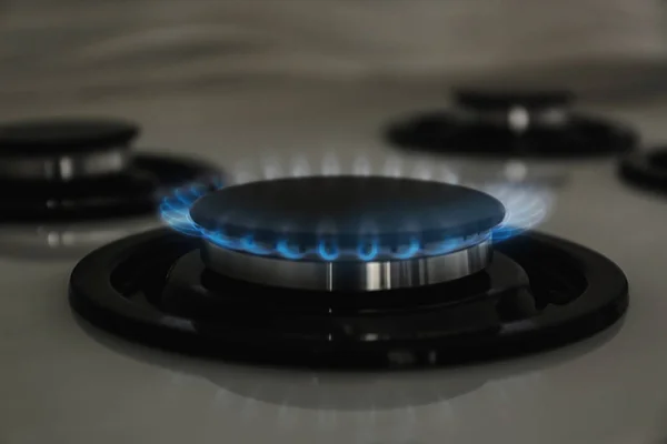 Gas burner with blue flame on modern stove, closeup — Stock Photo, Image