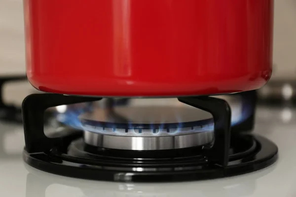 Cazuela roja en estufa de gas moderna, primer plano — Foto de Stock