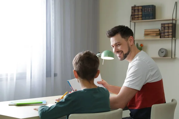 Papà aiuta suo figlio con l'incarico scolastico a casa — Foto Stock