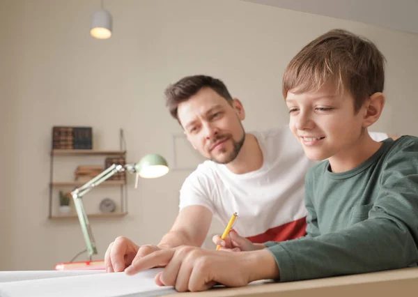 お父さんは自宅で学校の宿題で彼の息子を助ける — ストック写真