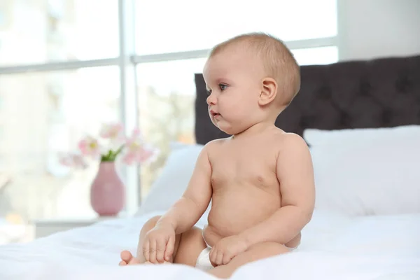 Bébé mignon en couche sur le lit à la maison — Photo