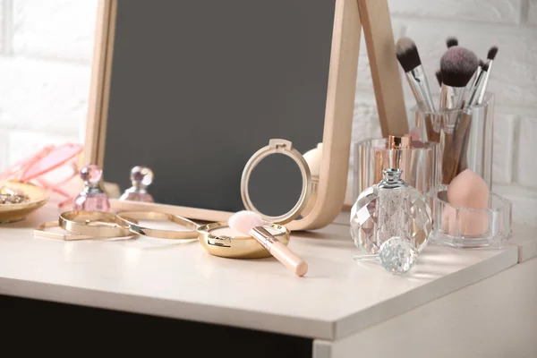 Diferentes produtos de maquiagem e acessórios na mesa de vestir — Fotografia de Stock