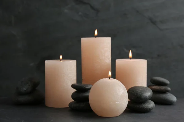 Composição de velas acesas e pedras de spa na mesa — Fotografia de Stock