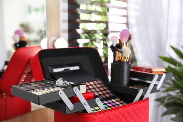 Beautician case with professional makeup products and tools on dressing table — Stock Photo, Image