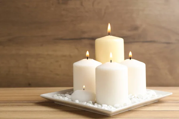 Тарелка с горящими свечами на деревянном столе. Пространство для текста — стоковое фото