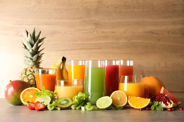 Окуляри з різними соками та свіжими фруктами на столі — стокове фото