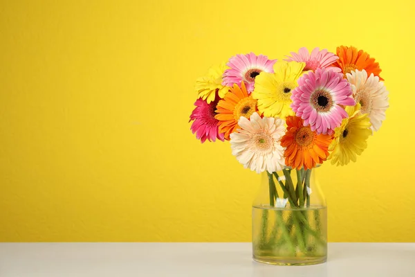 Renk arka plan karşı masada vazo güzel parlak gerbera çiçek Buket. Metin için alan — Stok fotoğraf