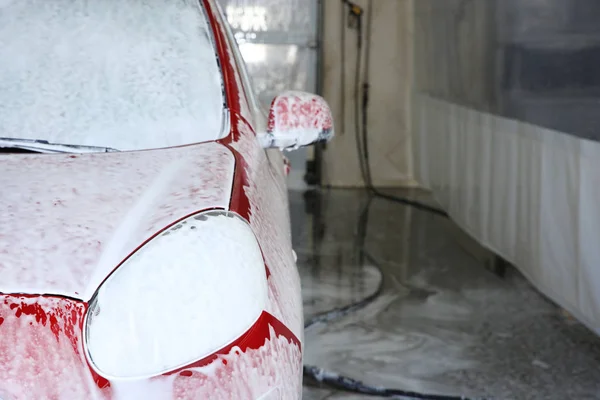 Auto καλύπτεται με αφρό στο πλύσιμο του αυτοκινήτου, Χώρος για το κείμενο. Υπηρεσία καθαριότητας — Φωτογραφία Αρχείου