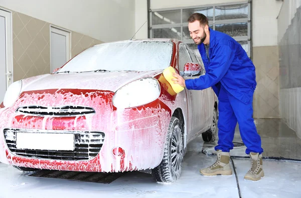 Trabajador de limpieza de automóviles con esponja en el lavado de coches profesional — Foto de Stock