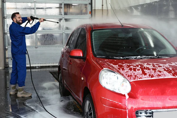 자동차 세차장에서 고압 물탱크를 사용하여 자동차를 청소하는 사람 — 스톡 사진