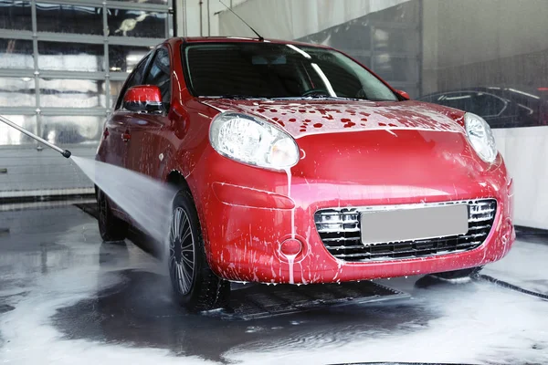 Cleaning modern automobile with high pressure water jet at car wash — Stock Photo, Image