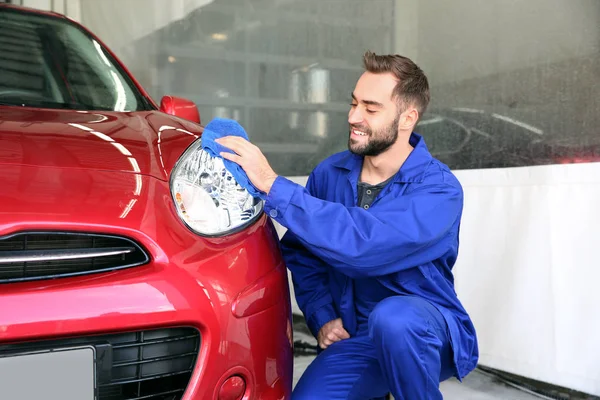 Trabalhador de limpeza do farol do automóvel com pano na lavagem do carro — Fotografia de Stock