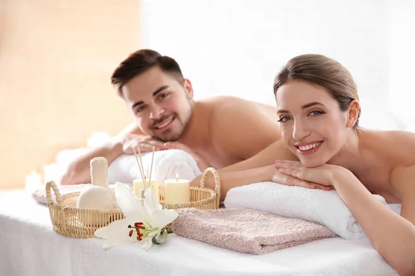 Young couple with spa essentials in wellness center — Stock Photo, Image