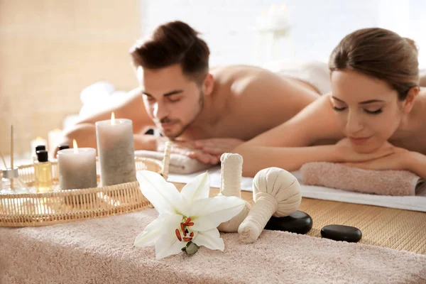 Young couple with spa essentials in wellness center — Stock Photo, Image