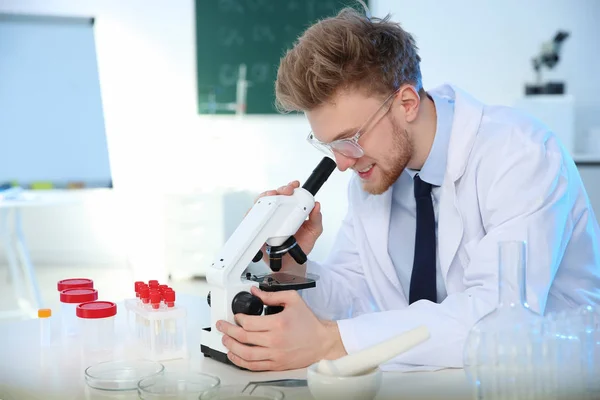 Mužský vědec používající moderní mikroskop v chemické laboratoři — Stock fotografie