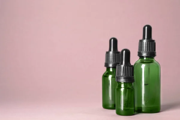 Cosmetische flessen van etherische oliën op kleur achtergrond. Ruimte voor tekst — Stockfoto