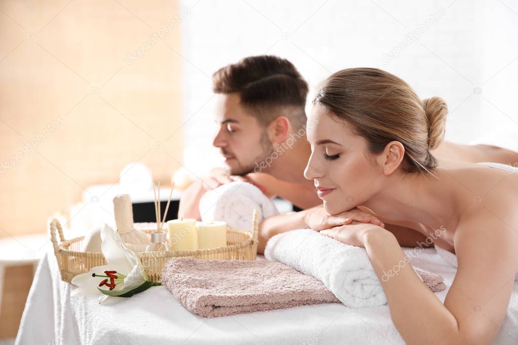 Young couple with spa essentials in wellness center