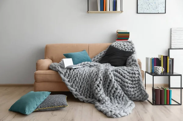 Wohnzimmereinrichtung mit bequemem Sofa und verschiedenen Büchern — Stockfoto