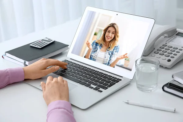 Kvinna med bärbar dator för konversation via videochatt vid bordet, närbild — Stockfoto