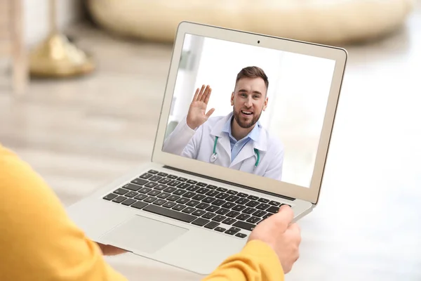 Homme utilisant un ordinateur portable pour la consultation en ligne avec le médecin par chat vidéo à la maison, gros plan — Photo