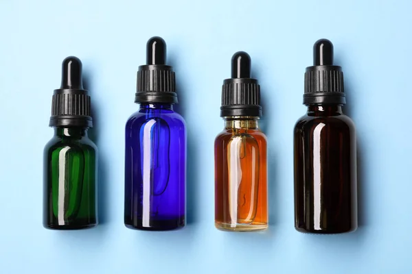 Platte lay samenstelling met cosmetische flessen van etherische oliën op kleur achtergrond — Stockfoto