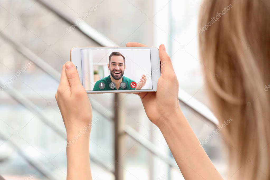 Young woman using smartphone for conversation with boyfriend via video chat indoors, closeup