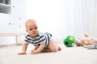 Sevimli küçük bebek kapalı halı üzerinde sürünerek