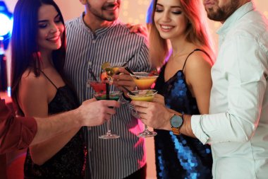 Partide martini kokteyli tutan bir grup genç